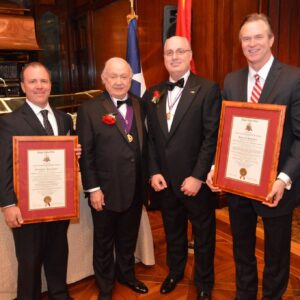 four men in suits standing together two with certificates