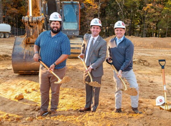 three men holding shovels and dirt
